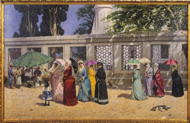 Osman Hamdi Bey’s Ladies Taking a Walk, 1887, depicting women in colourful dresses and veils carrying parasols beside a stone wall with geometric grilles.